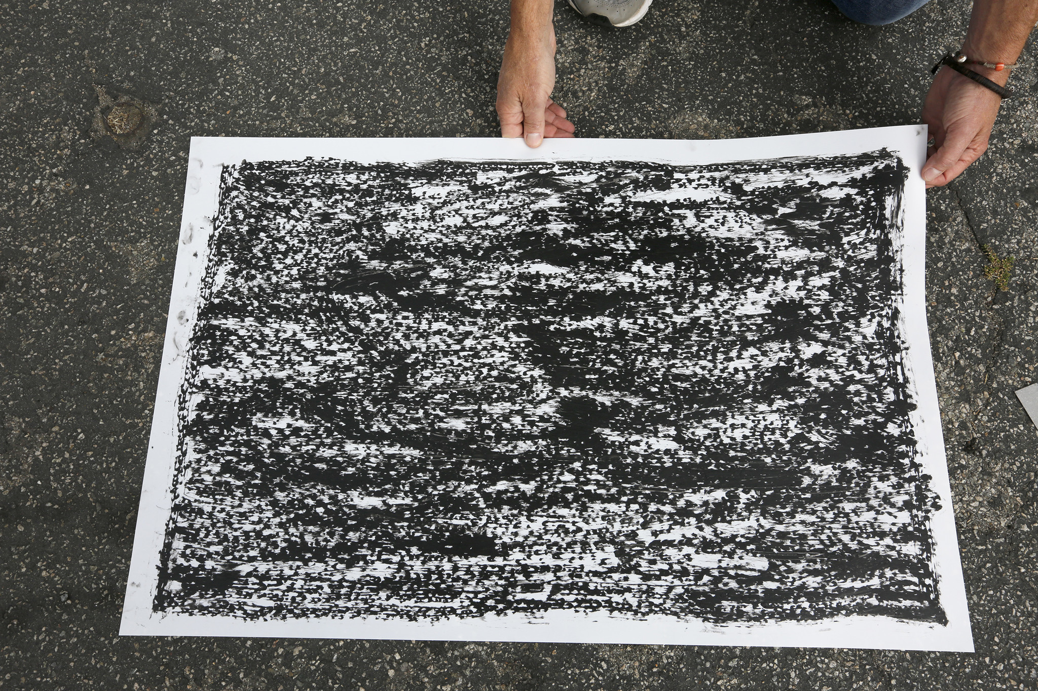 Artist Jeff Beall displays one of the rubbings taken at the site of an unsolved death related to the 1992 L.A. riots — in this case that of a 23-year-old Latino man named Arturo C. Miranda.