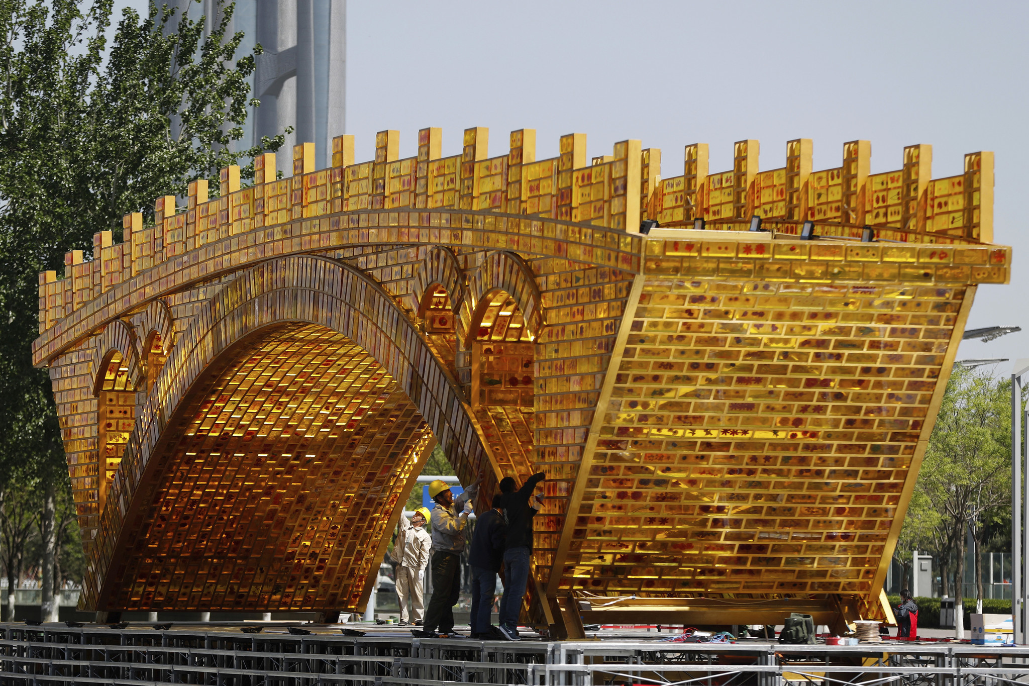 Workers last month install wires on the "Golden Bridge of Silk Road" structure outside the National Convention Center in Beijing. (Andy Wong / Associated Press)