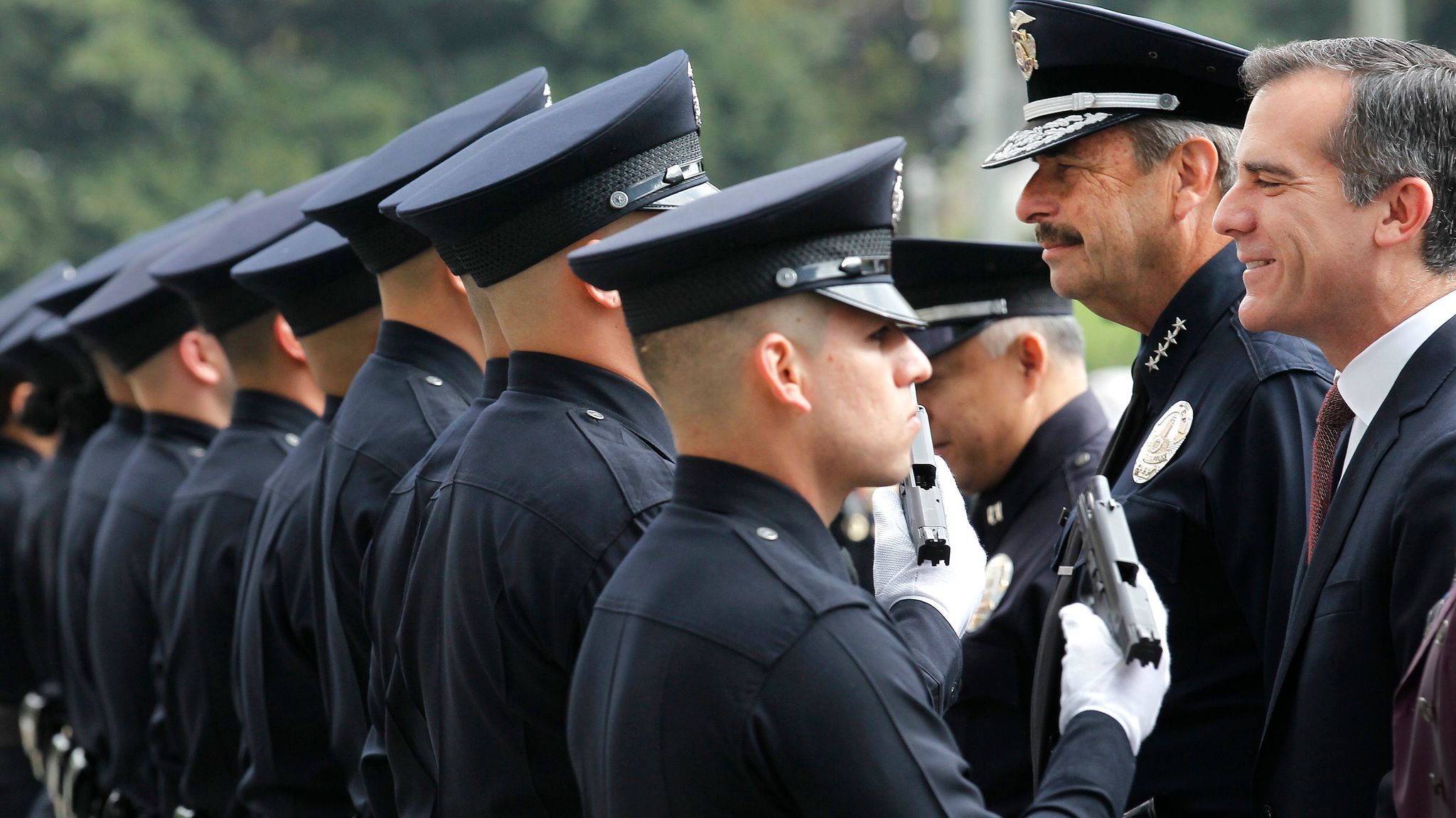 Police Chief Charlie Beck, second from right, and Mayor Eric Garcetti, right. inspect a new group of LAPD officers at a 2015 graduation ceremony.
