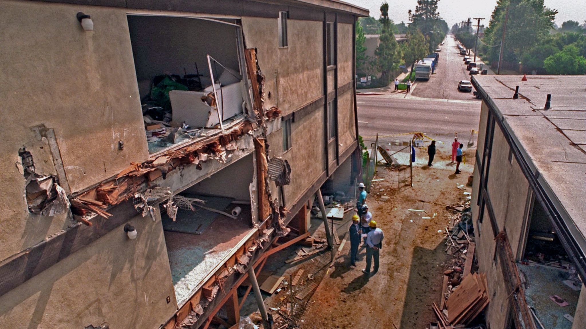 Workers begin to demolish the Northridge Meadows apartment building, whose ground floor collapsed in the 1994 earthquake.