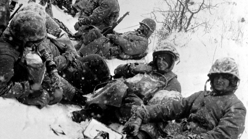 U.S. Marines, fighting their way from the communist encirclement at Chosin to Hungnam, rest in the snow in December 1950, a few months into the Korean War.
