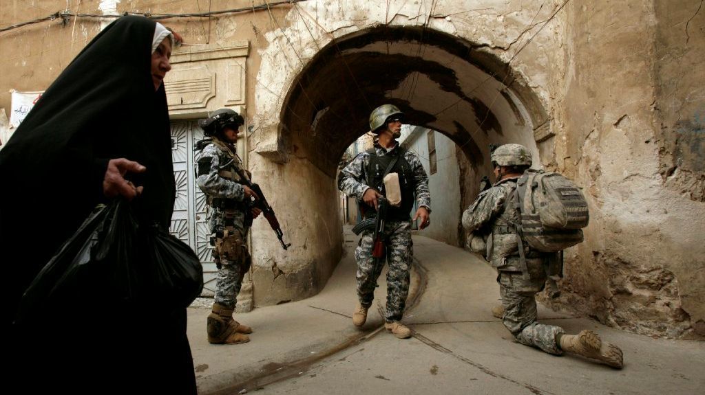 U.S. troops and Iraqi police officers stand guard in Mosul, Iraq, in  2003.