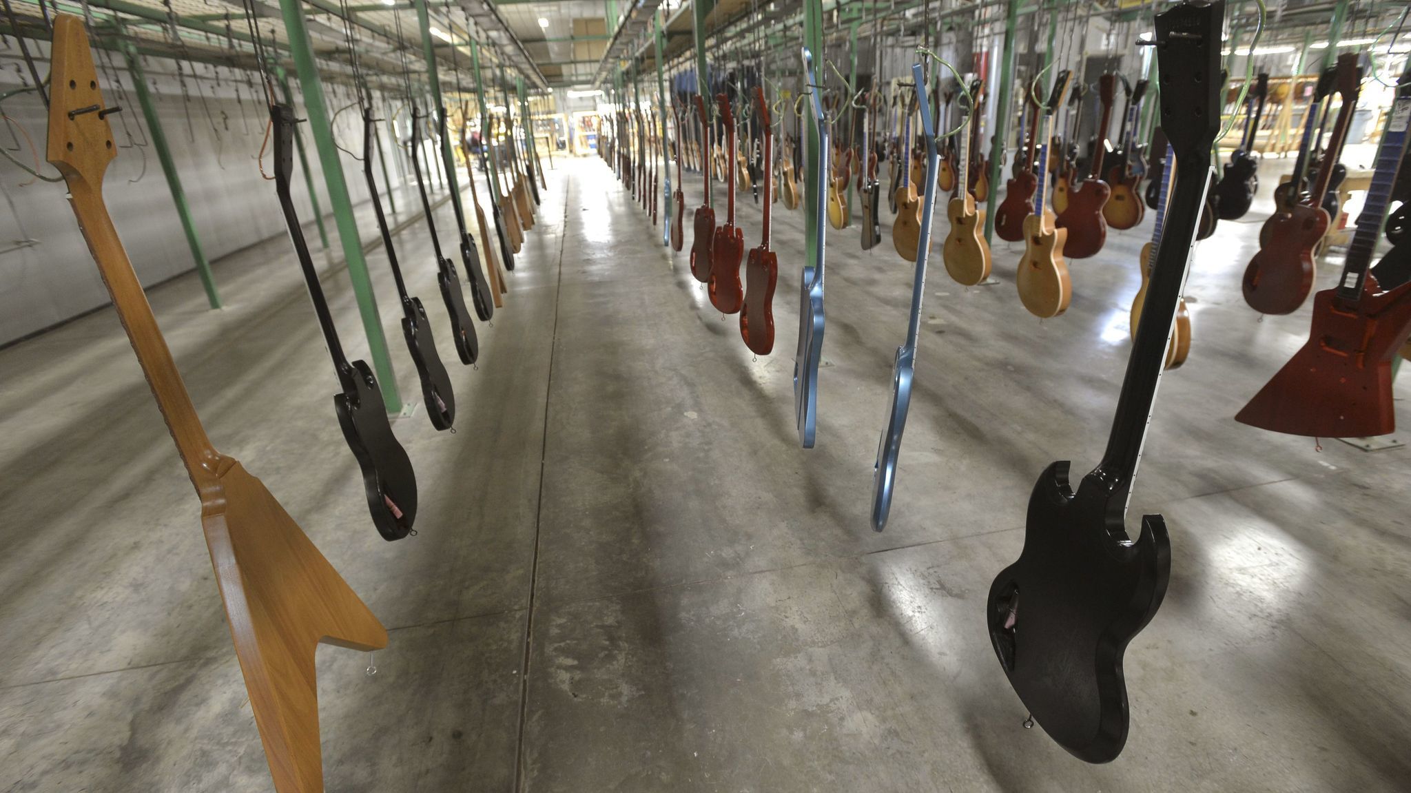 New guitars hang, waiting to have final finish applied at the Gibson guitar manufacturing plant in Nashville.