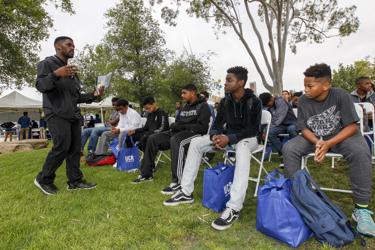 Admissions counselor De'Von Walker, left, speaks to young students visiting UC Riverside through the Council of African American Parents program on Highlander Day.