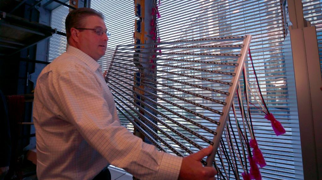 James Hart, StandardVision construction director, holds a section of the LED screen at the Wilshire Grand Center.