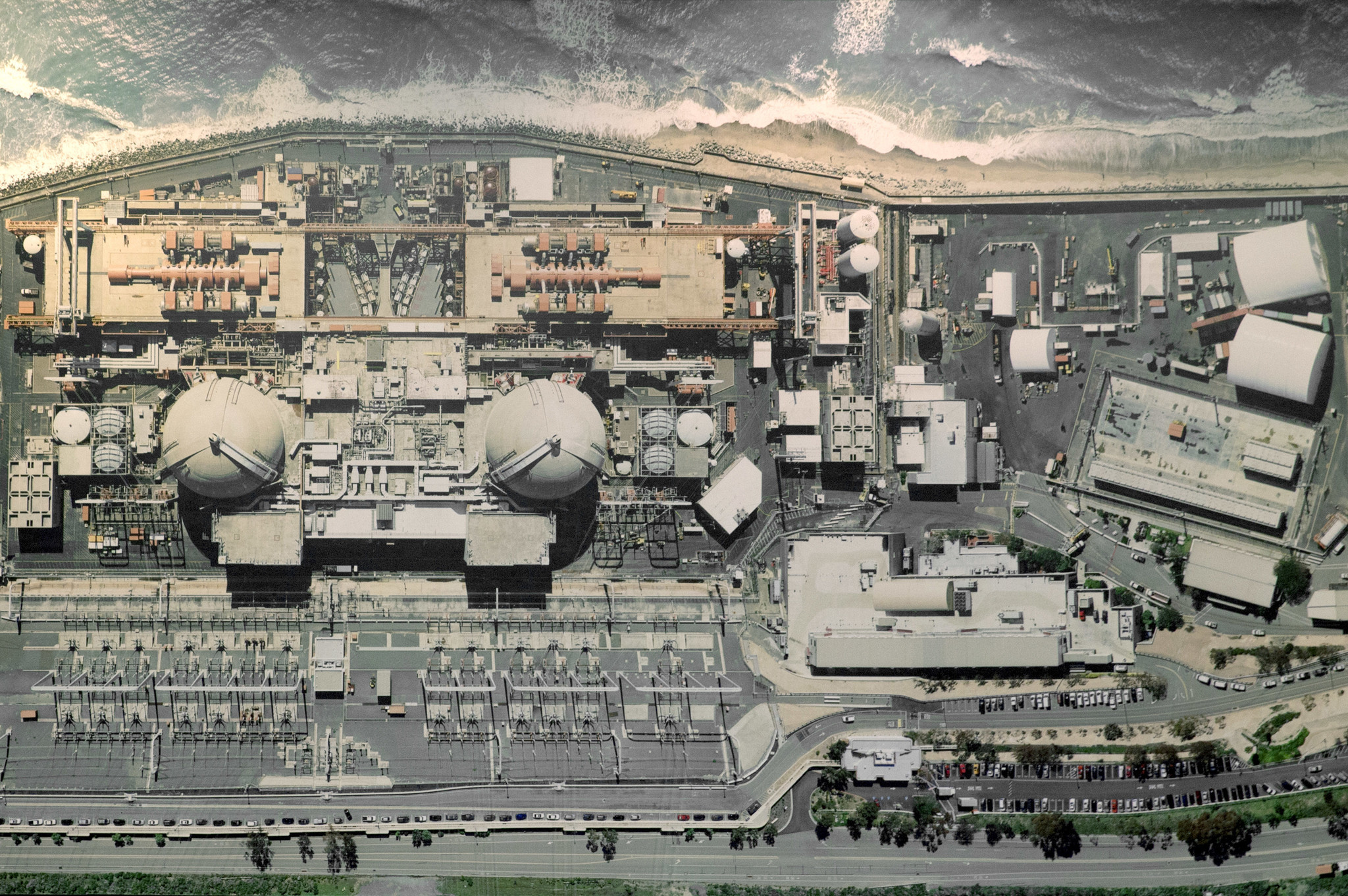 An aerial view of the closed San Onofre Nuclear Generating Station hangs on the wall of a conference room at the facility.