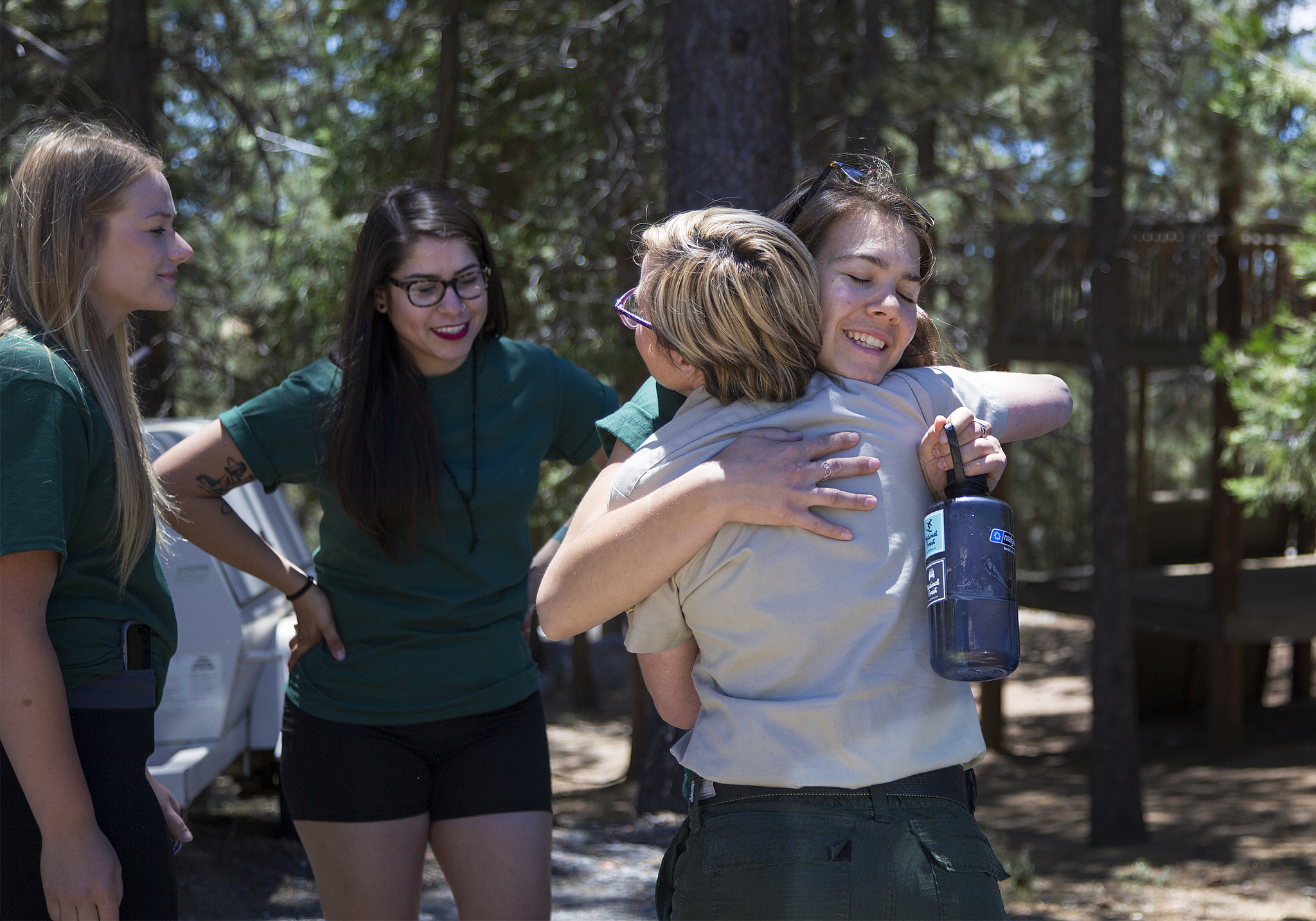 Adela Montserrat Valencia of Cameron Park, holding a water bottle, gets a hug from Kristen Allison of the U.S. Forest Service after graduating from the training camp.