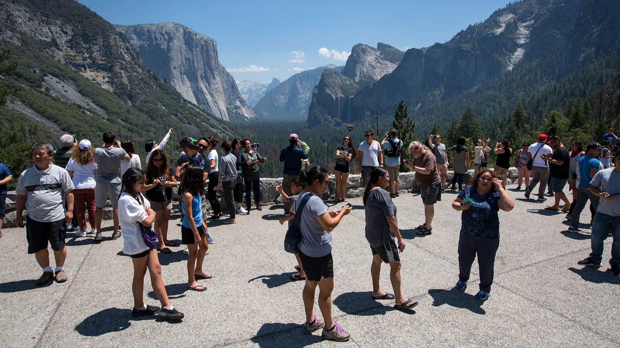 Visitors crowd Yosemite's Tunnel View overlook.