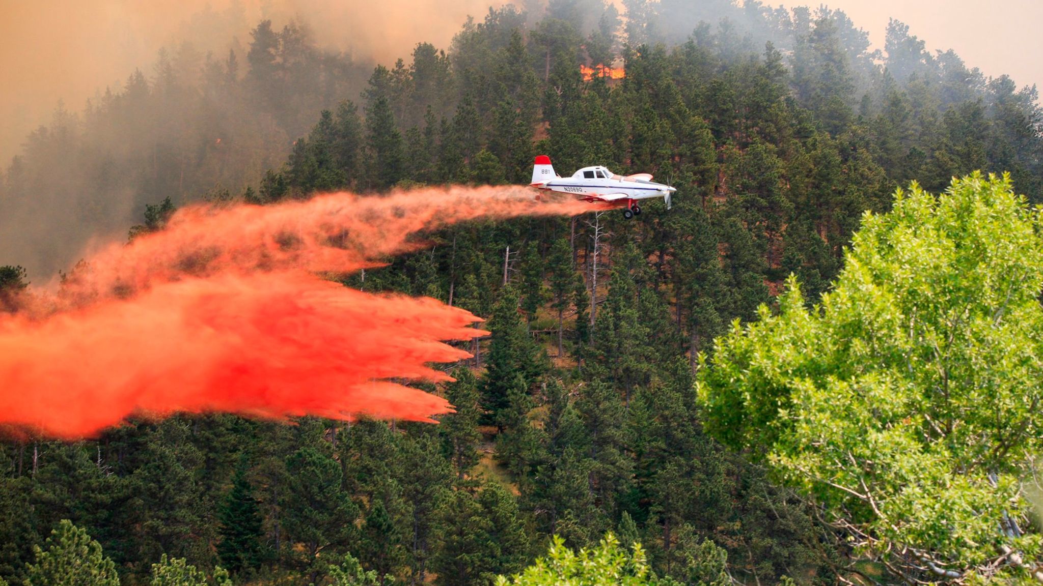 A plane drops retardant on a wildfire near the historic mining town of Landusky, south of the Fort Belknap Indian Reservation in north-central Montana.