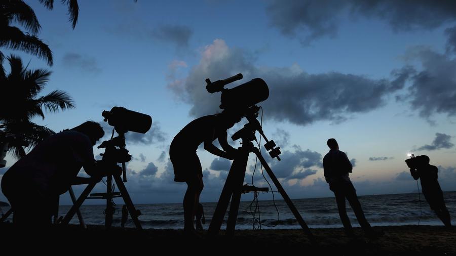 Telescopic cameras and computer equipment are set up on Palm Cove beach in Cairns, Australia to live