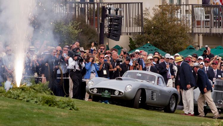 Fans and judges watch a 1954 Ferrari 375 MM Scaglietti Coupe drive up to accept the Best of Show awa
