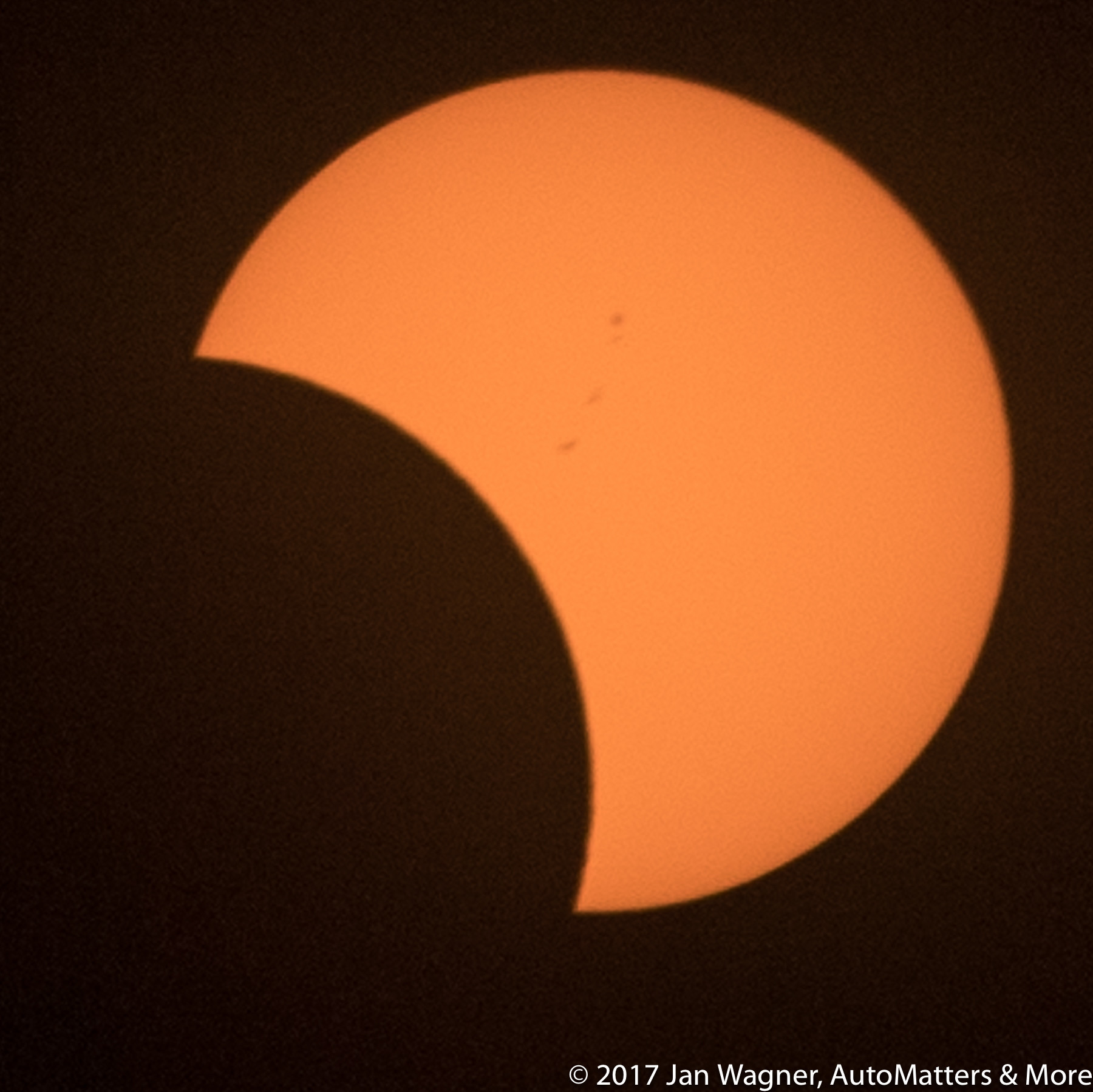 Partial solar eclipse with sunspots
