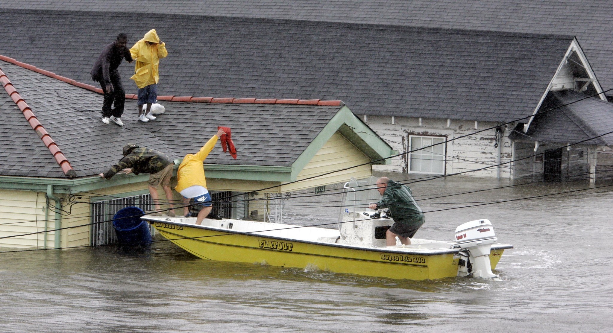 Boaters rescue Bryan Vernon and Dorothy Bell in New Orleans. Hundreds remained trapped on roofs or in attics.