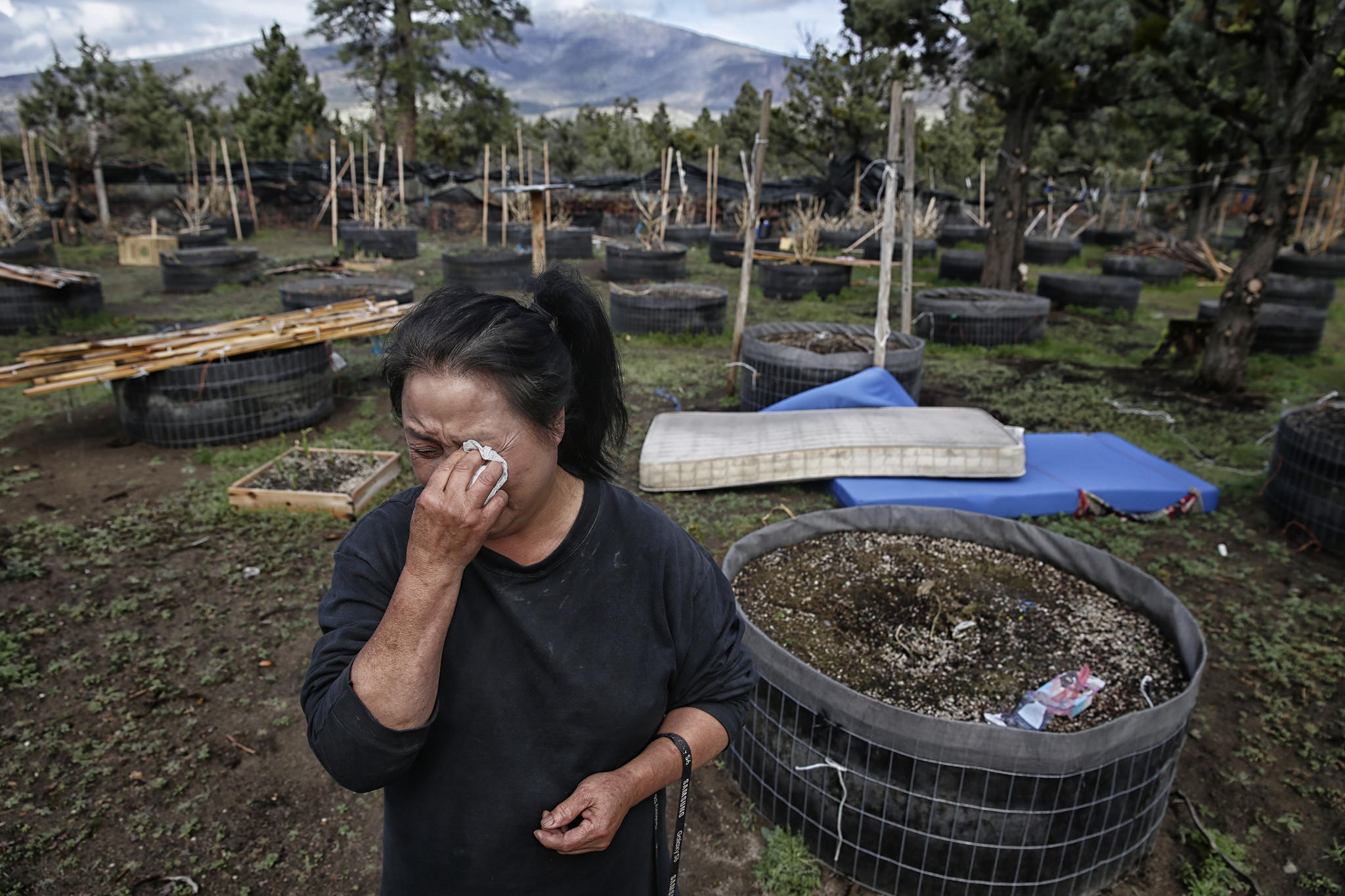 Bao Kelly Xiong weeps as she clears the belongings of her sister, Mee Xiong, from her Mt. Shasta Vista property.  Mee died of asphyxiation last winter when she used charcoal in a pot to heat a small enclosure she bedded down in at night.