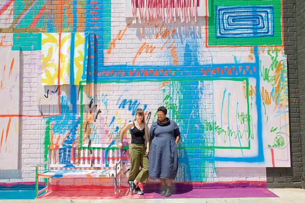 Artist Sarah Cain (left) and ICA curator Jamillah James stand by Cain’s mural in the courtyard.