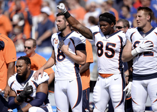 Denver Broncos tight end Virgil Green (85) gestures as teammate Max Garcia, left, takes a knee during the playing of the national anthem prior to an NFL game against the Buffalo Bills on Sept. 24.