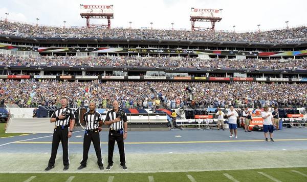 Officials stand on the sideline before a game between the Seattle Seahawks and the Tennessee Titans. Neither team came out onto the field for the anthem.