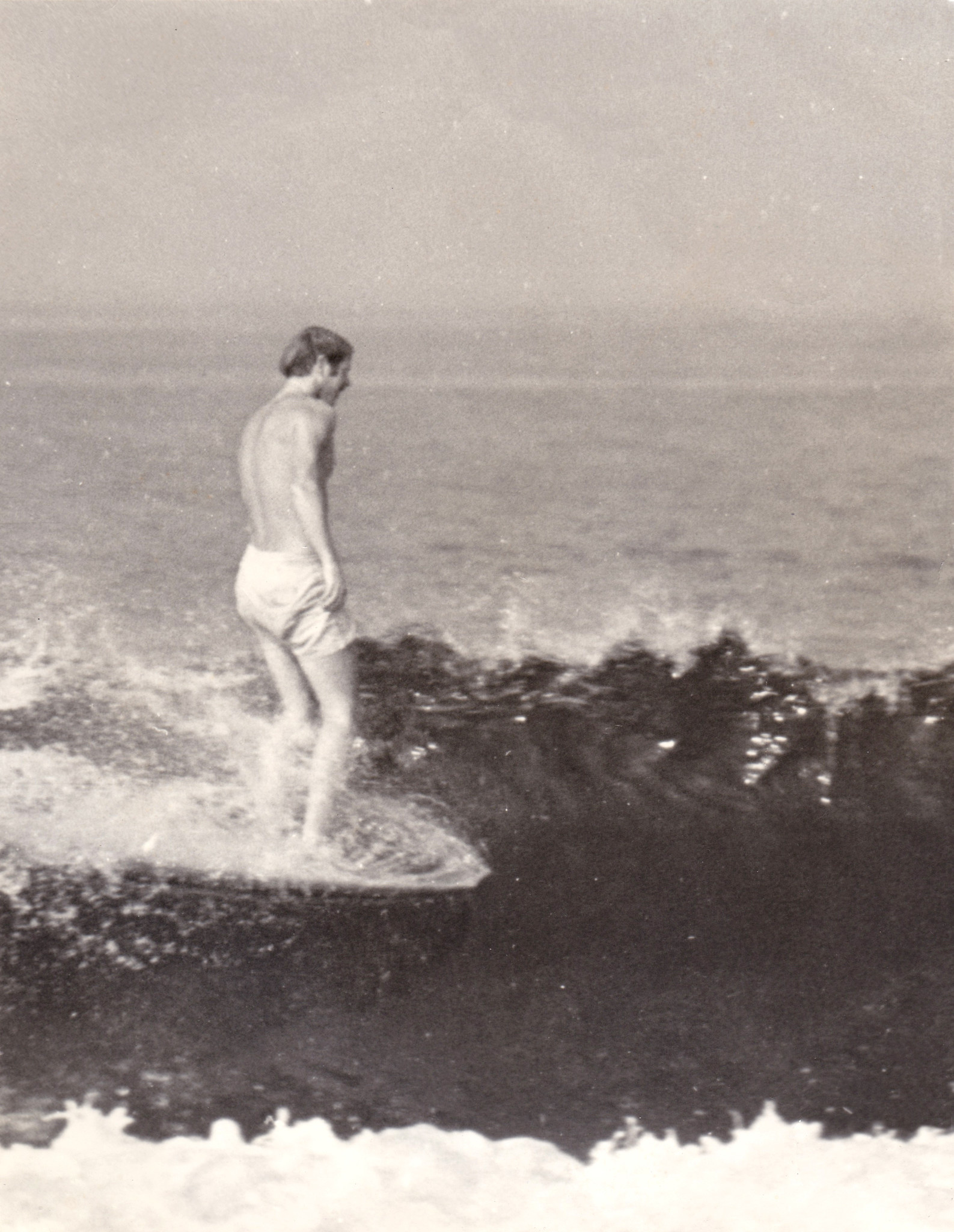 Bill Andrews rides a wave in earlier days.