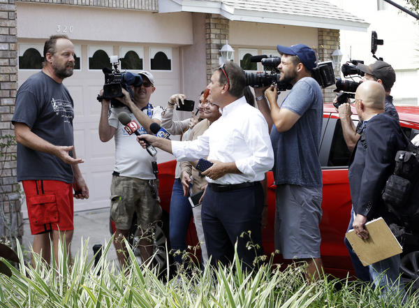 Eric Paddock, left, brother of Las Vegas gunman Stephen Paddock, speaks to members of the media outside his home Monday in Orlando, Fla. (John Raoux / Associated Press)
