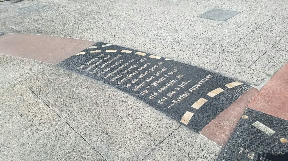 Mosaic texts that tell stories of men and women who came to work in Hollywood are embedded in the pavement.