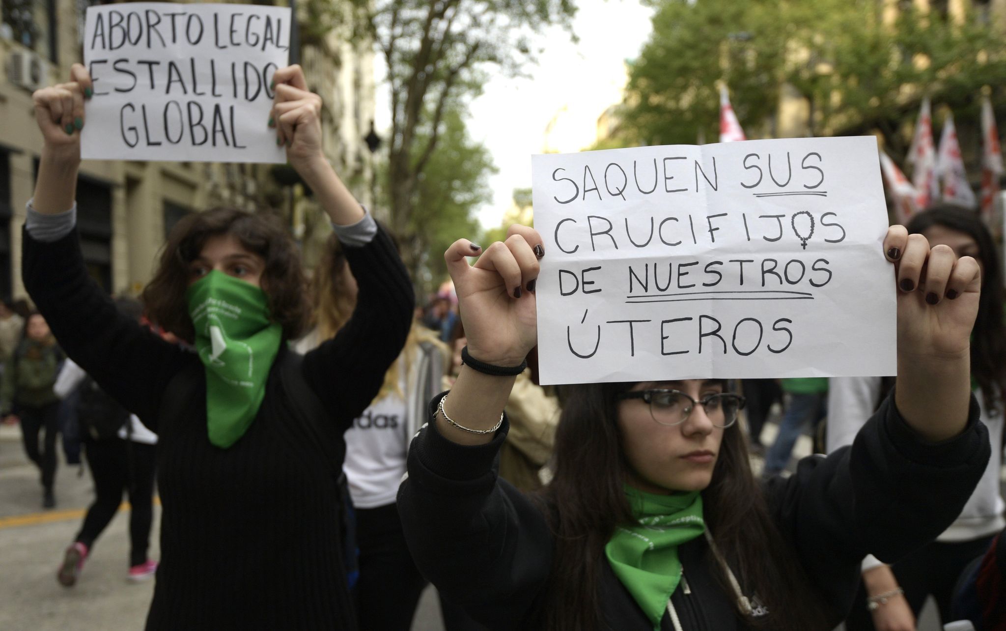 Women hold signs reading "Legal abortion, global outbreak" (L) and "Take your crucifixes from our wombs" during a September protest demanding the decriminalization of abortion in Buenos Aires.