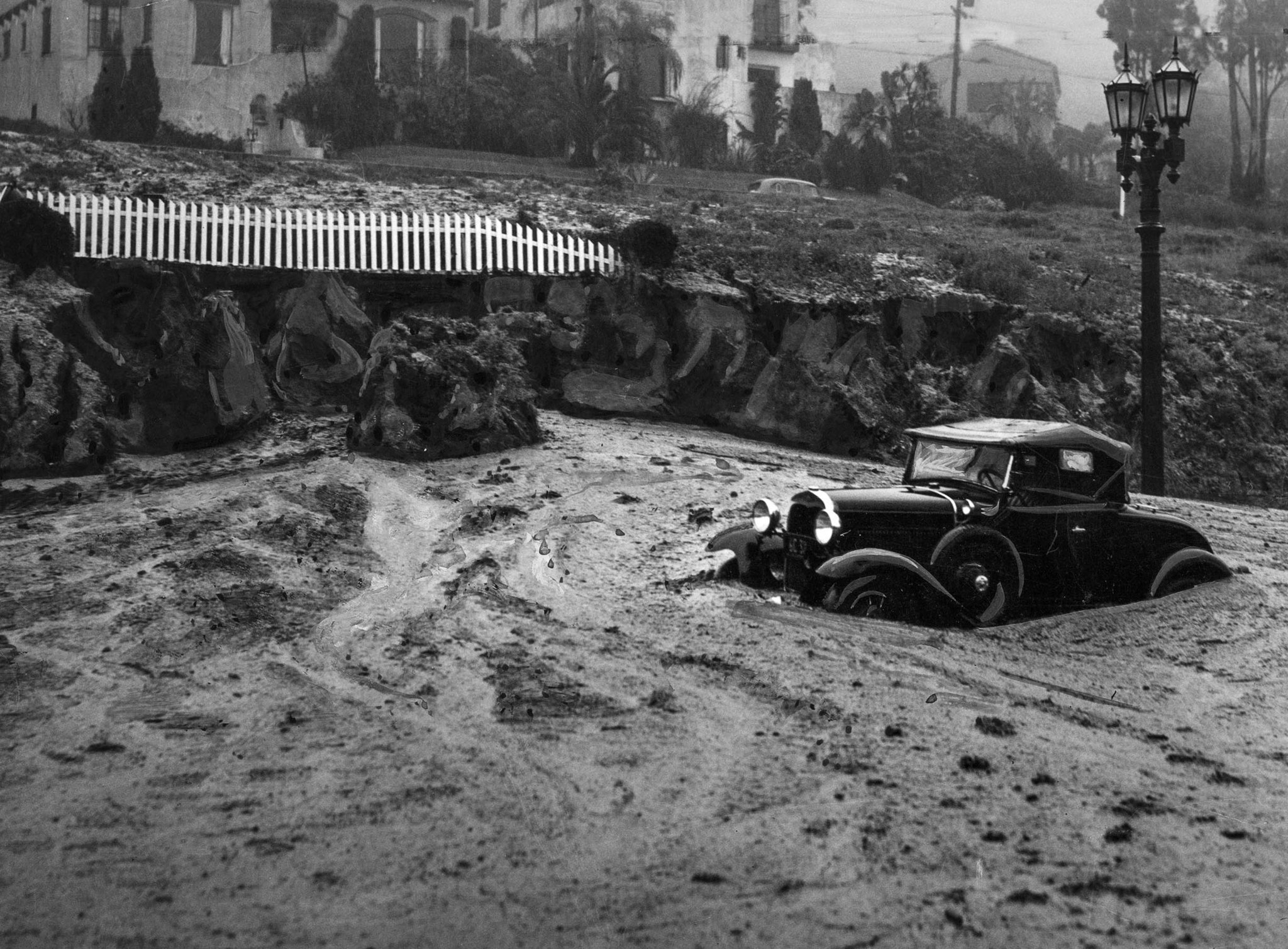 March 2, 1938: Mud slide at Harper Avenue and Sunset Boulevard caught this automobile and closed the