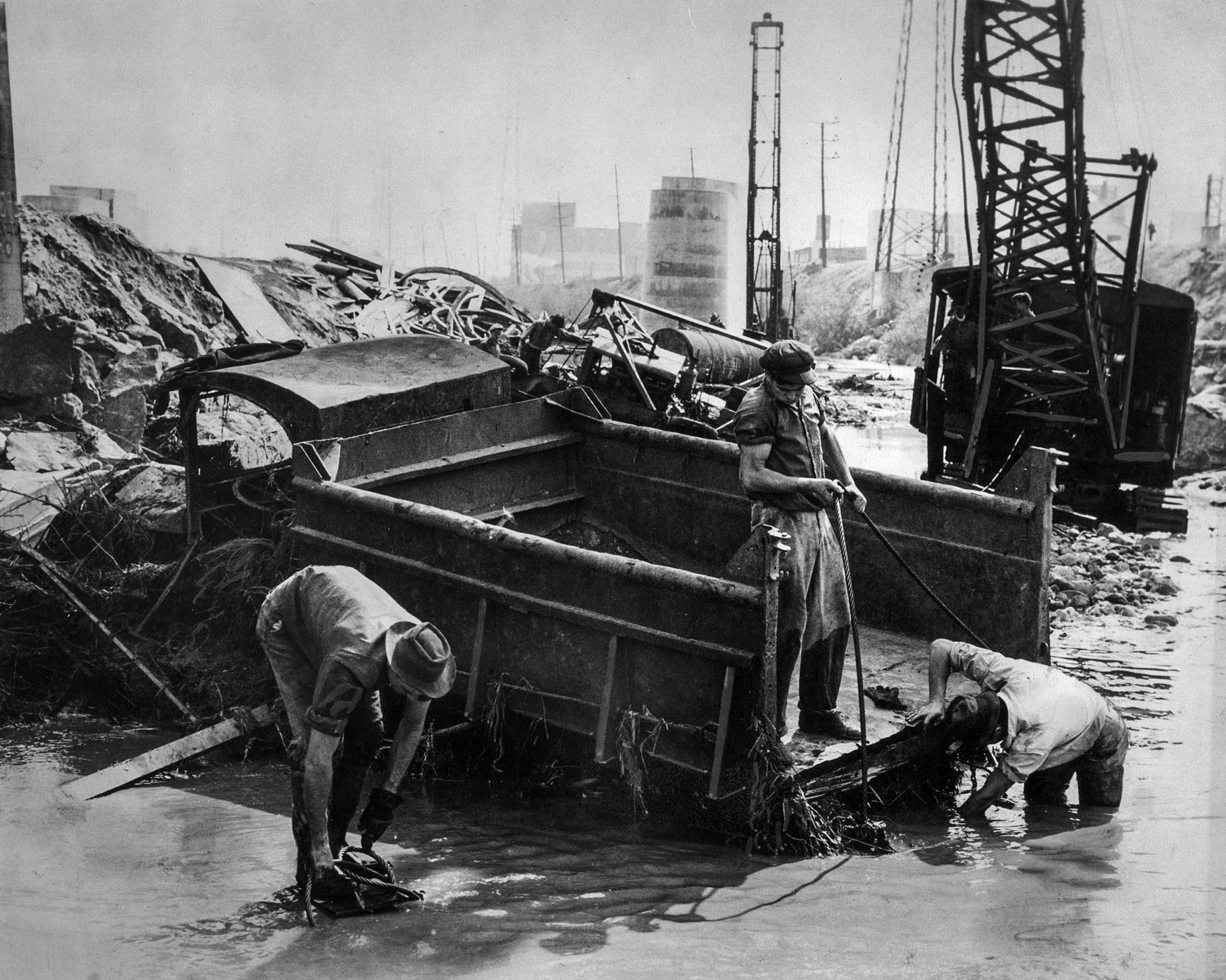 March 2, 1938: Salvage crew trys to dig out gravel truck damaged by flooding along the Los Angeles R