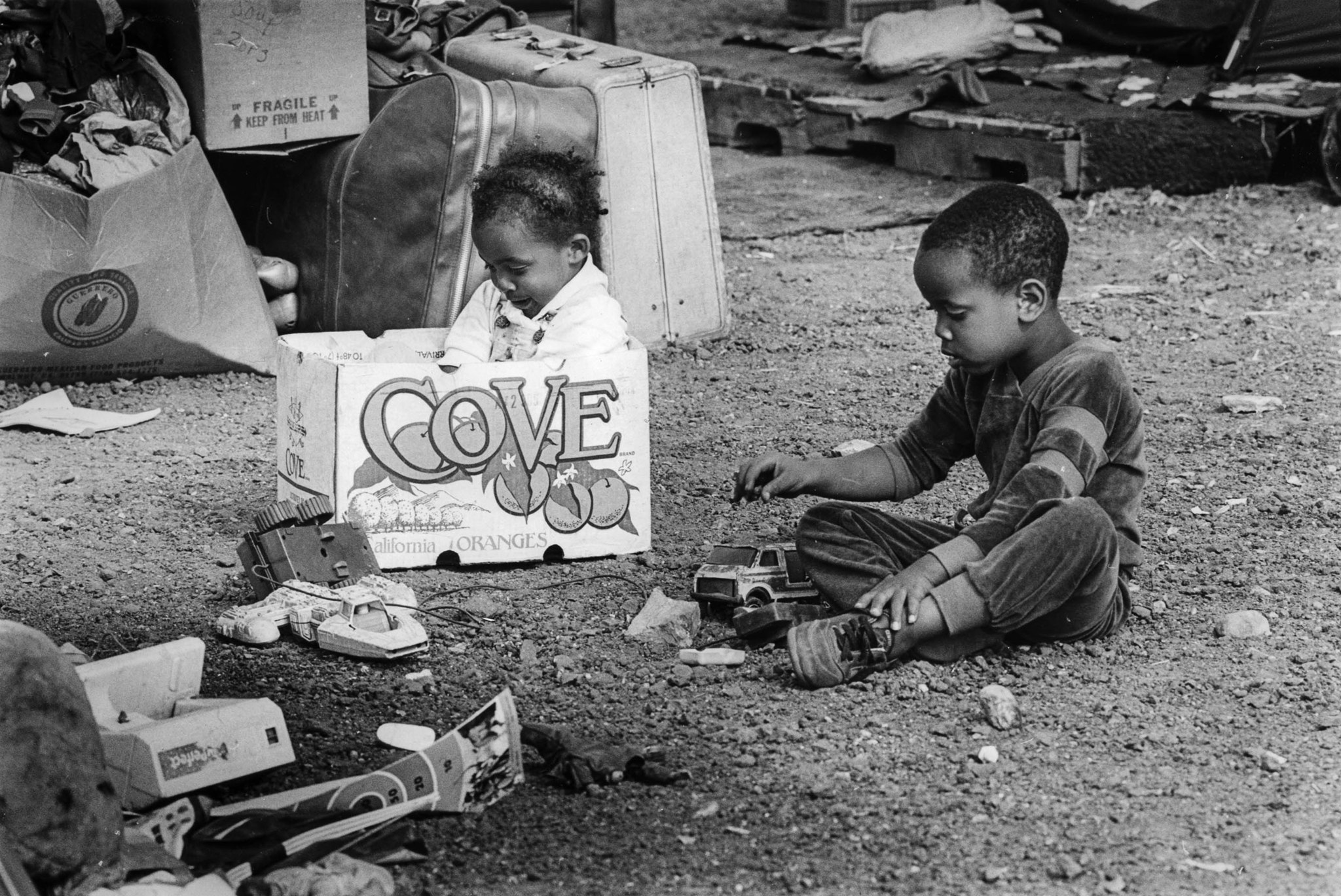 June 26, 1987: Two children play with toys and an empty box at the Urban Campground. This photo was