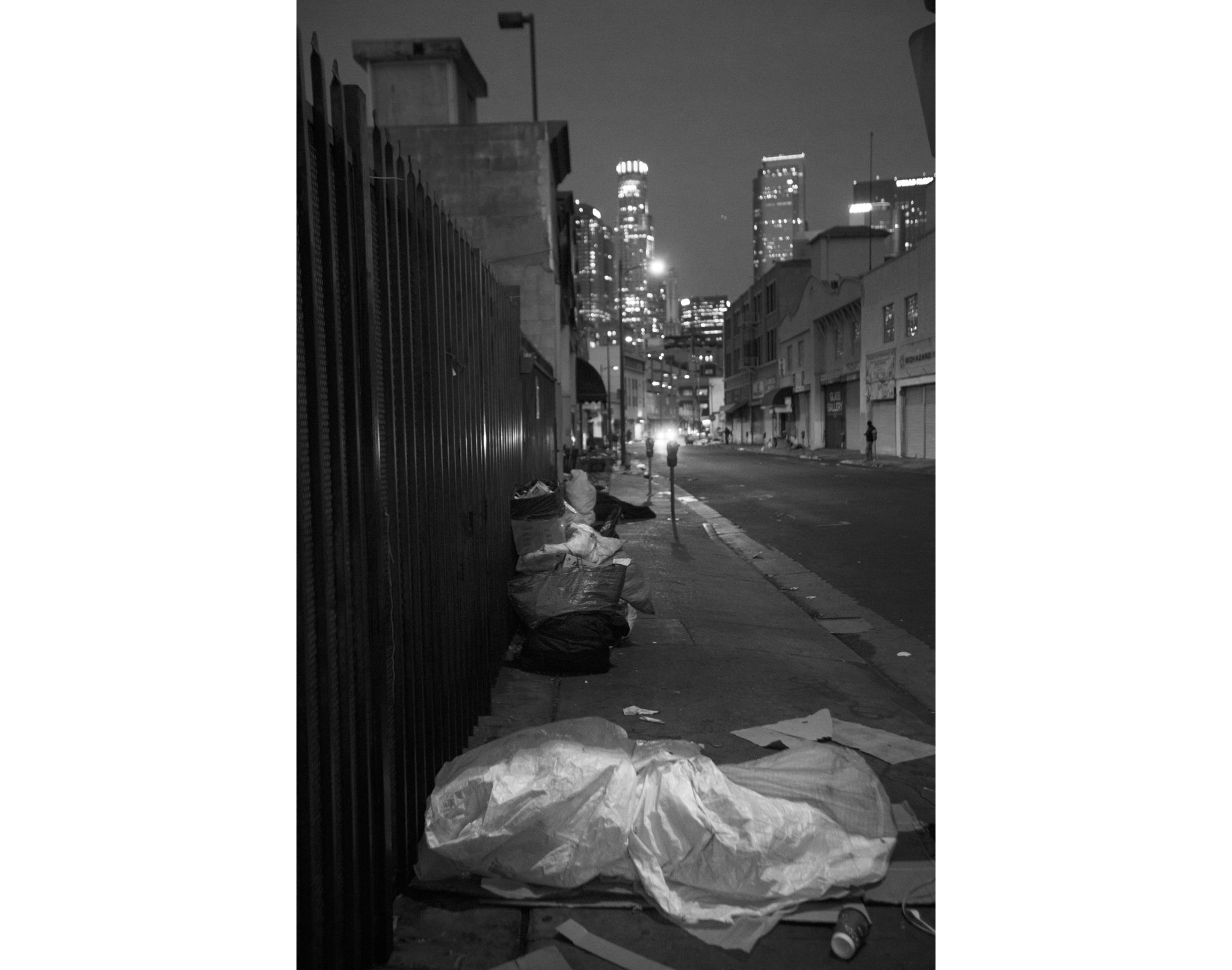 LOS ANGELES, CA NOVEMBER 15, 2017: At dawn people are sleeping on the sidewalk wrapped in tarps and