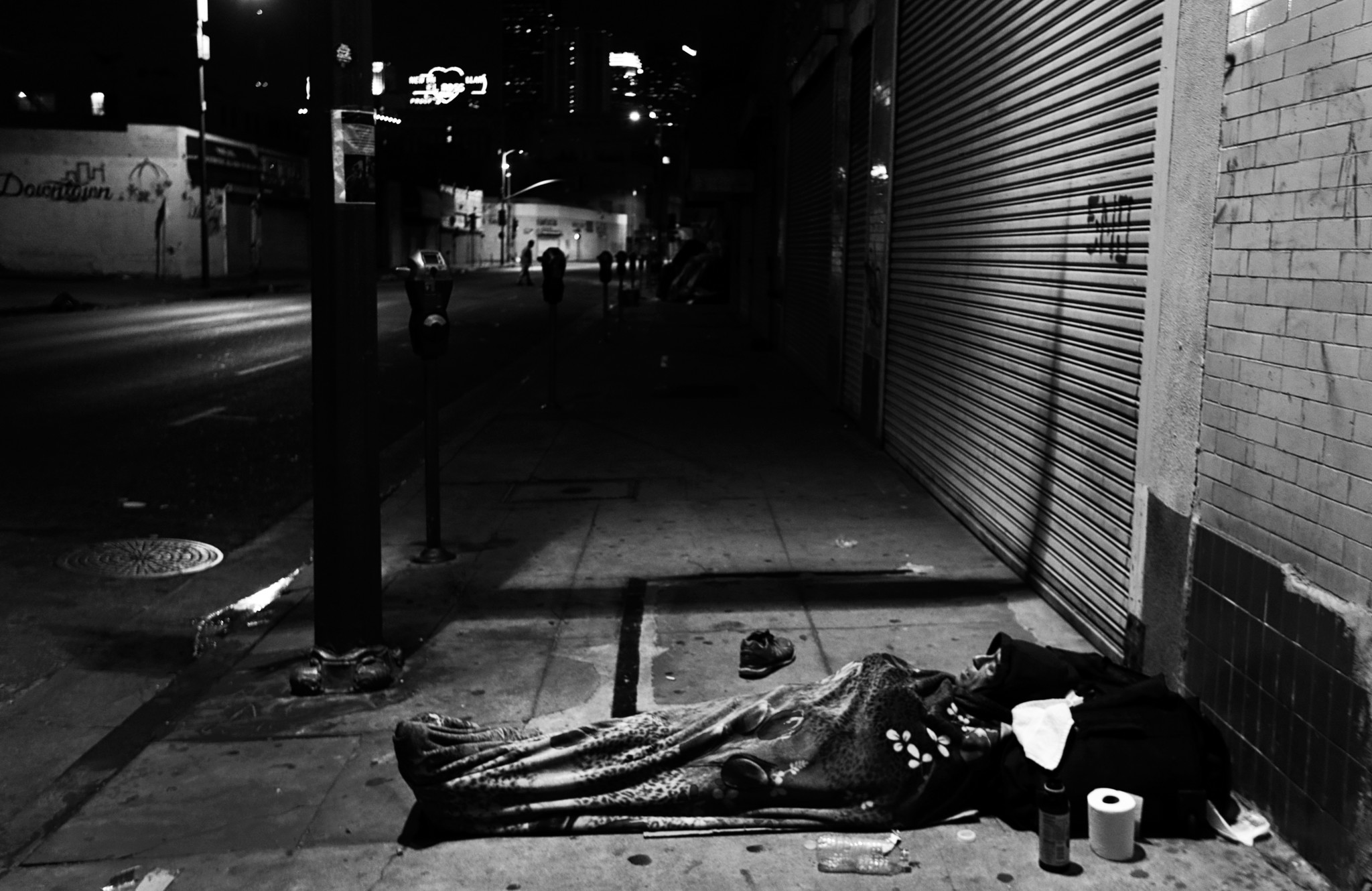 LOS ANGELES, CA February 2, 2018: A man sleeps on the slide walk beneath a blanket in downtown Los A