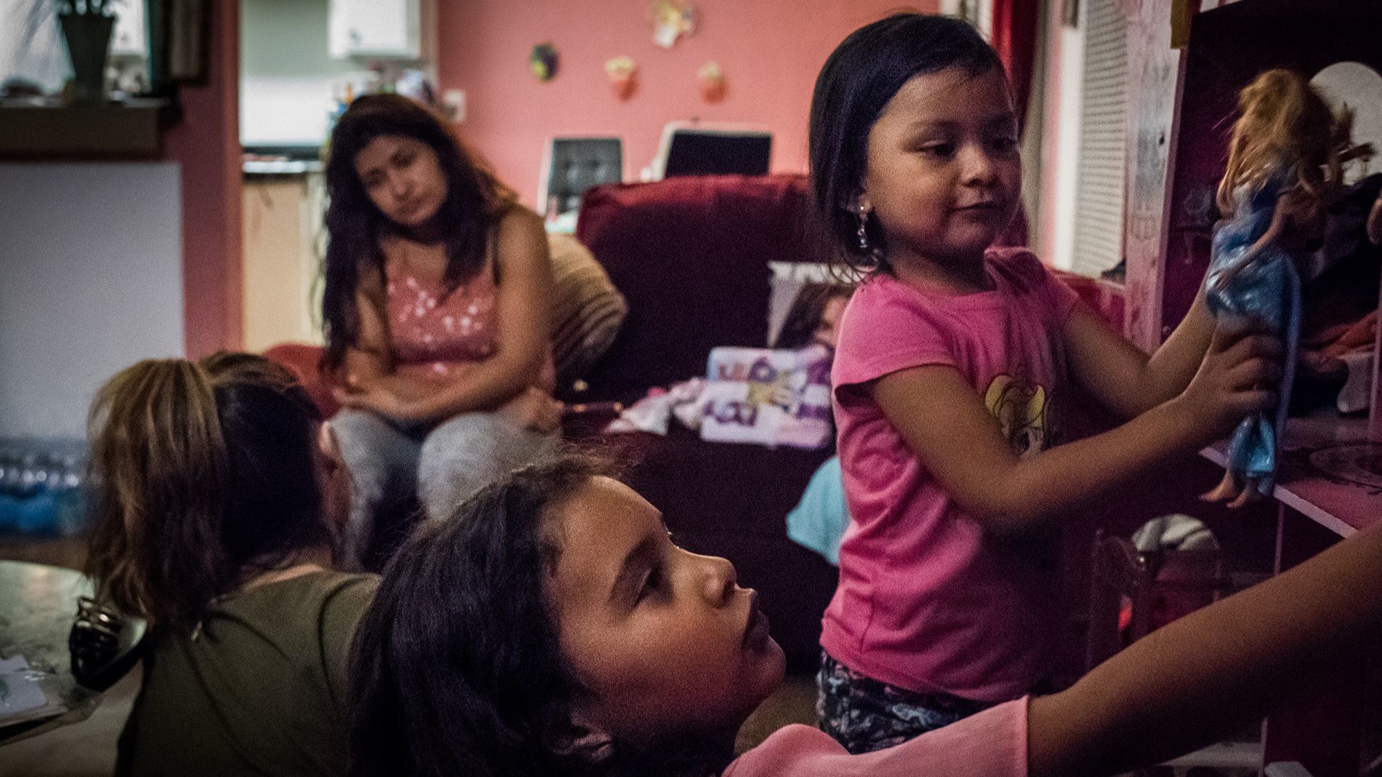 NORTHRIDGE, CA - June 19, 2018 Marley, center, and Kati play with a dollhouse while their mothers,