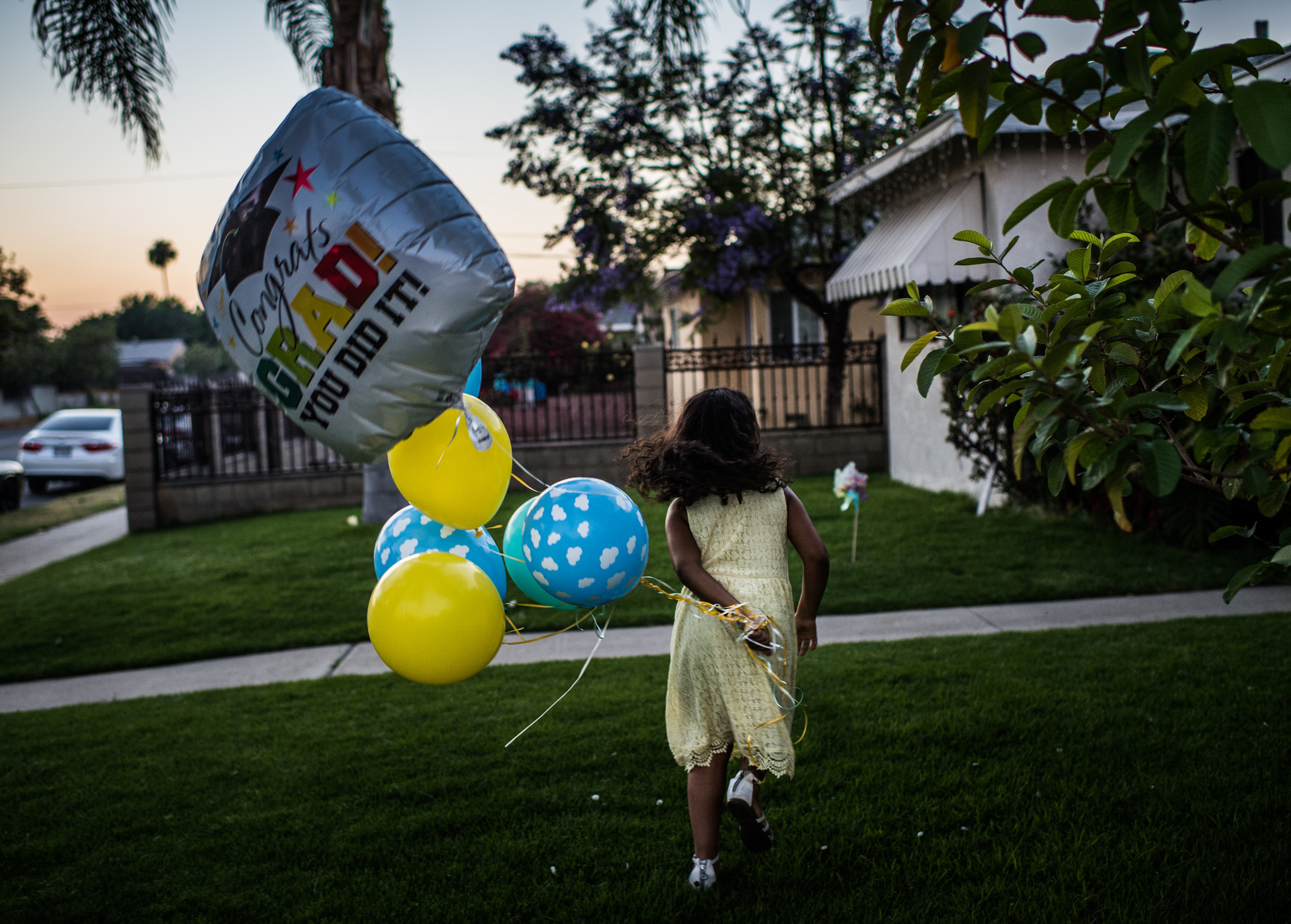ARLETA, CA - June 21, 2018 Following her Kindergarten graduation, Marley runs with balloons outside