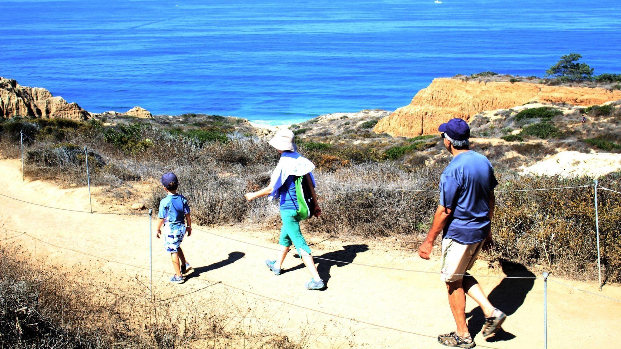 A family with a young boy walks the Yucca Trail above Torrey Pines State Beach, near where a woman was bitten by a rattlesnake a few days before.