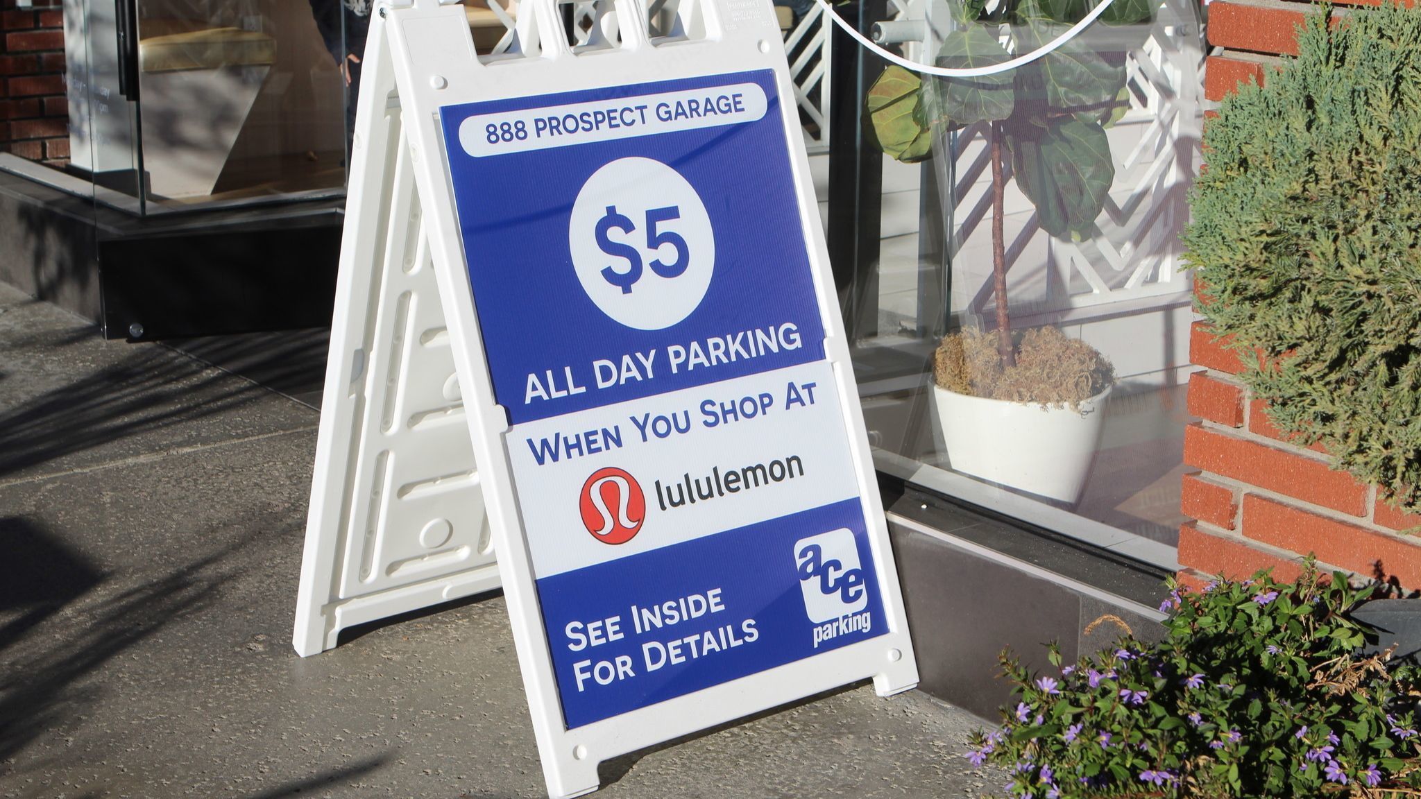 An a-frame sign advertises Ace Parking's $5 all-day parking validation program for participating La Jolla merchants.